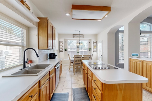 kitchen featuring sink, a kitchen island, a healthy amount of sunlight, and black electric cooktop