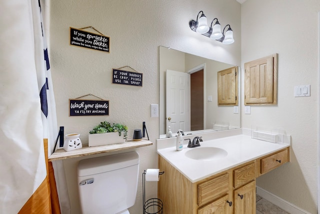 bathroom featuring toilet and vanity