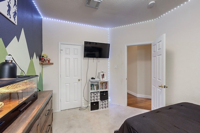 carpeted bedroom featuring a textured ceiling