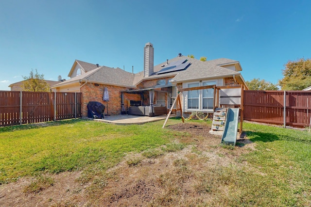 back of house featuring a patio, solar panels, and a yard