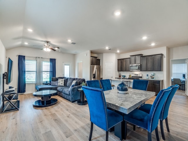 dining area featuring light hardwood / wood-style flooring, ceiling fan, and vaulted ceiling