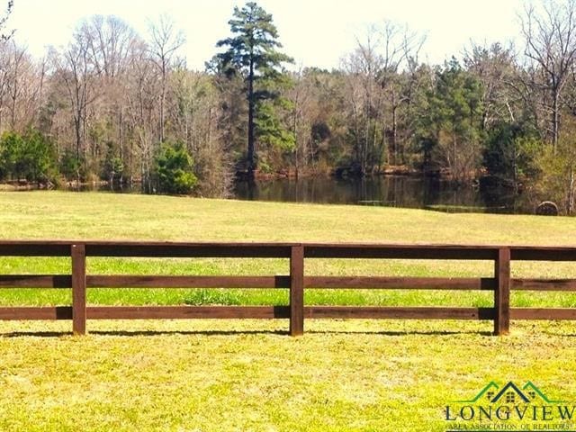 view of gate with a lawn