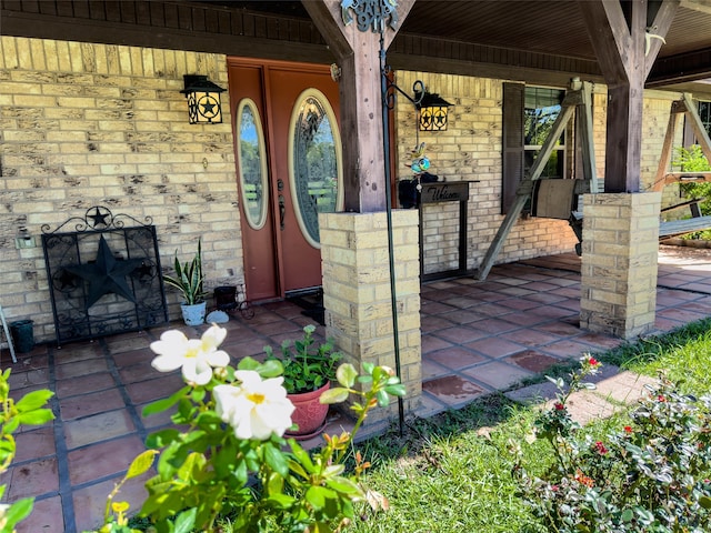 view of exterior entry featuring covered porch