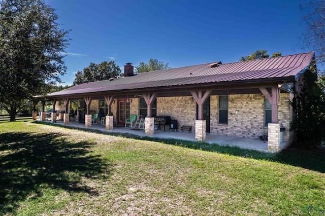 back of house with a yard and a patio area