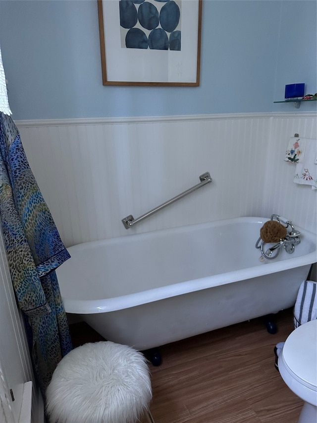 bathroom featuring a tub, hardwood / wood-style flooring, and toilet