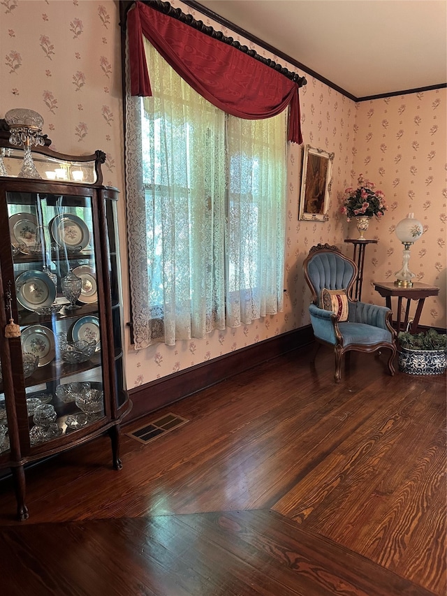 living area featuring crown molding and hardwood / wood-style flooring