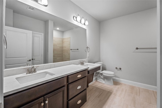 bathroom featuring vanity, hardwood / wood-style floors, toilet, and walk in shower