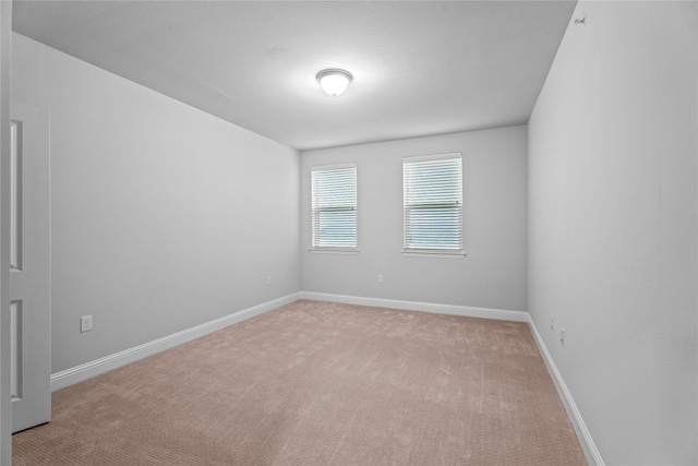 spare room featuring light colored carpet