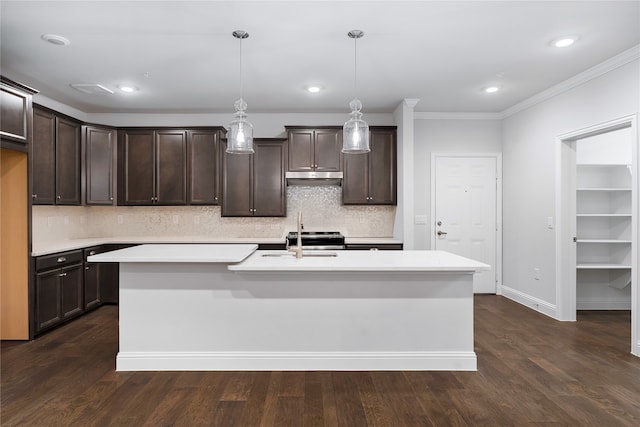 kitchen featuring dark brown cabinetry, dark hardwood / wood-style floors, hanging light fixtures, and a center island with sink