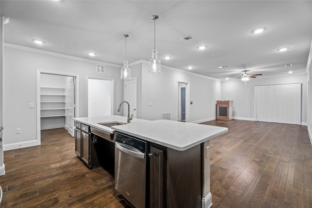 kitchen featuring pendant lighting, sink, dishwasher, dark brown cabinets, and a center island with sink