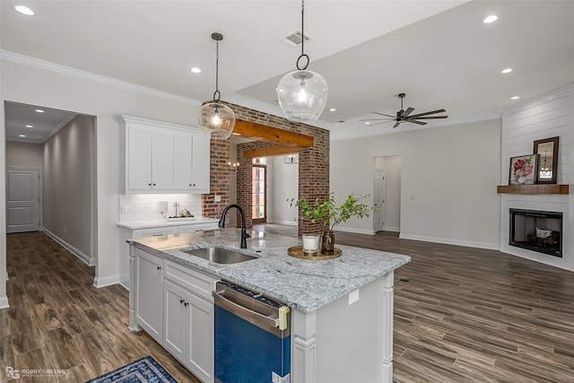 kitchen featuring stainless steel dishwasher, white cabinetry, sink, and a center island with sink