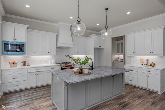 kitchen featuring white cabinets and a kitchen island with sink