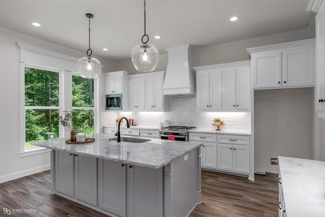 kitchen with stainless steel appliances, white cabinetry, sink, custom exhaust hood, and pendant lighting