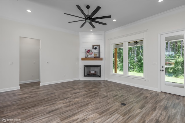 unfurnished living room featuring dark wood-type flooring, a fireplace, ceiling fan, and crown molding