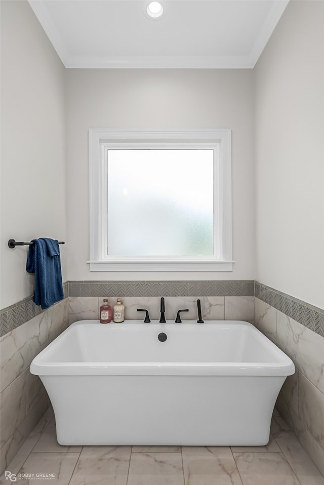 bathroom featuring tile walls, a tub, and crown molding