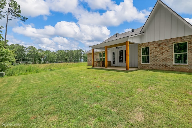 rear view of house with ceiling fan, a lawn, french doors, and a patio area