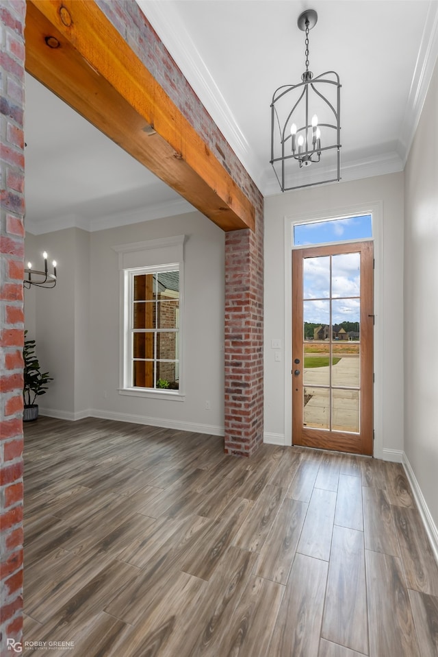 interior space featuring dark wood-type flooring, a chandelier, and crown molding