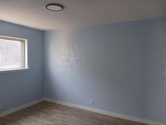 unfurnished room with light hardwood / wood-style floors and a textured ceiling