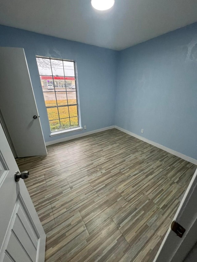 unfurnished room with hardwood / wood-style flooring