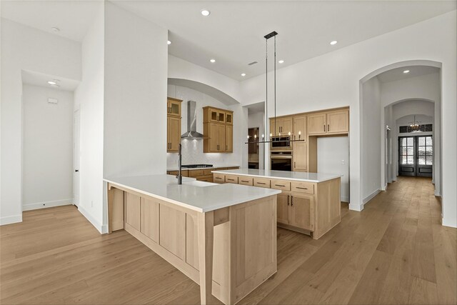 kitchen featuring tasteful backsplash, dark hardwood / wood-style floors, pendant lighting, a center island with sink, and appliances with stainless steel finishes