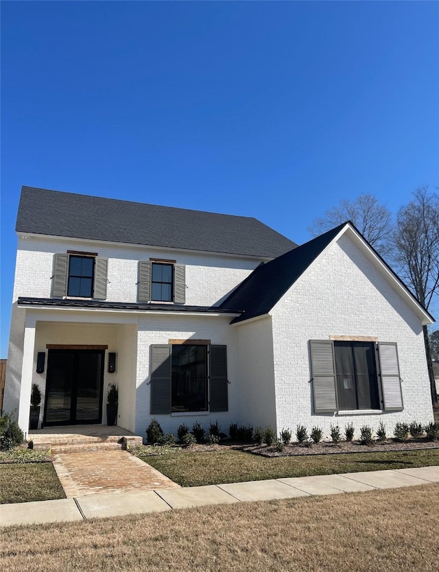 view of front facade with a front yard and covered porch