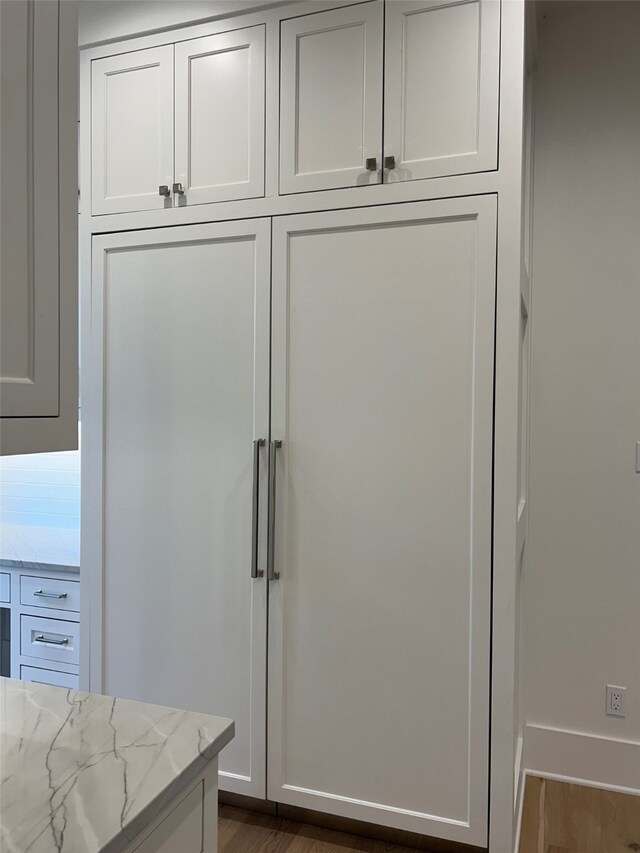 interior details with light hardwood / wood-style floors, white cabinetry, backsplash, and stainless steel stove