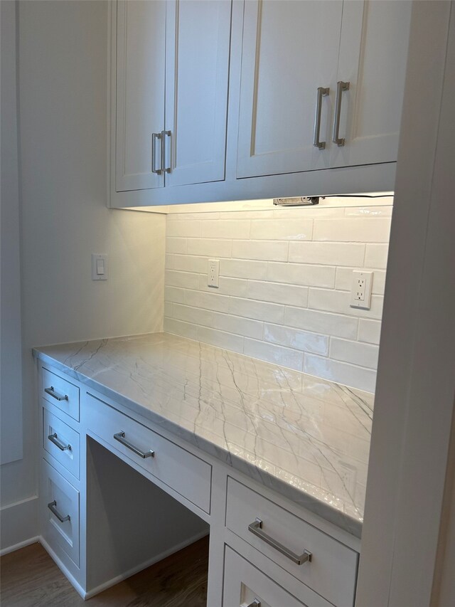 kitchen with sink, hanging light fixtures, light stone countertops, dishwashing machine, and light hardwood / wood-style floors