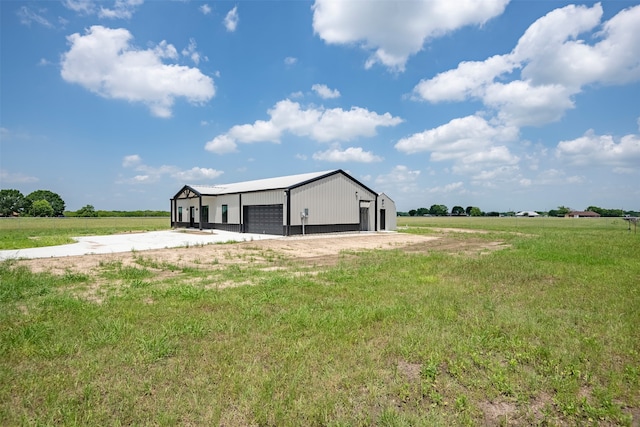 view of home's exterior featuring a garage, a rural view, an outdoor structure, and a yard