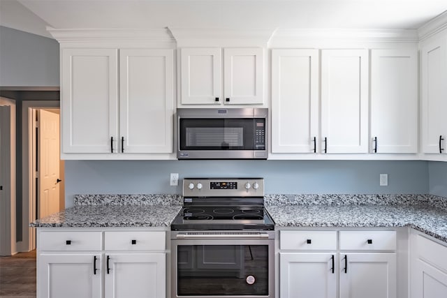 kitchen featuring white cabinets, stainless steel appliances, and light stone countertops