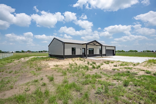 manufactured / mobile home featuring a garage, a rural view, and an outdoor structure