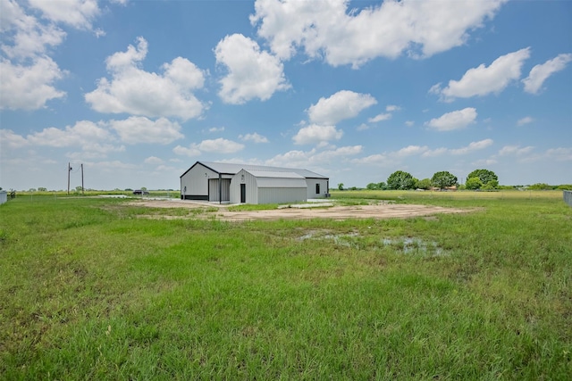 view of yard with an outbuilding and a rural view