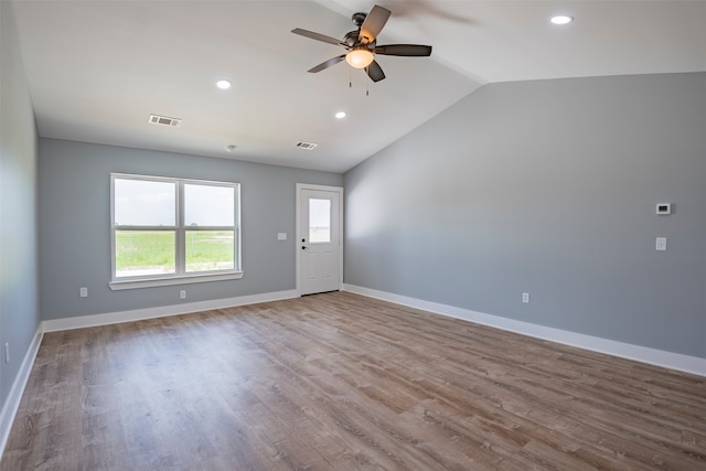 empty room with hardwood / wood-style floors, ceiling fan, and vaulted ceiling