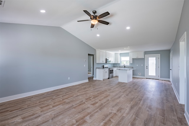 unfurnished living room with ceiling fan, light wood-type flooring, sink, and vaulted ceiling