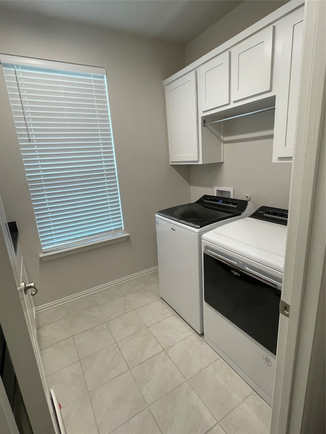 laundry area featuring cabinets, light tile patterned floors, and independent washer and dryer