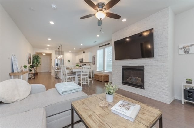 living room with dark hardwood / wood-style floors, a fireplace, and ceiling fan