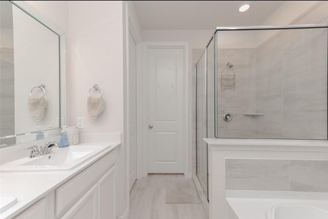 bathroom with independent shower and bath and dual bowl vanity