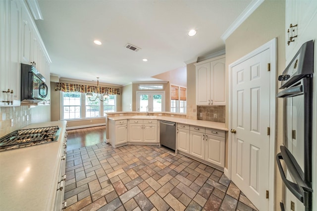 kitchen featuring black appliances, decorative light fixtures, white cabinetry, and tasteful backsplash