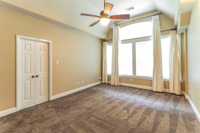 carpeted empty room with ceiling fan and vaulted ceiling