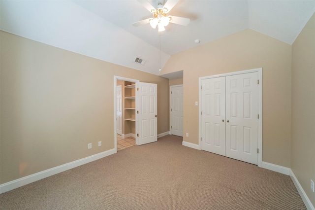 unfurnished bedroom with light colored carpet, vaulted ceiling, and ceiling fan