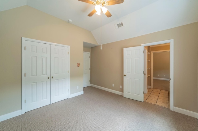 unfurnished bedroom featuring ceiling fan, a closet, carpet, and lofted ceiling