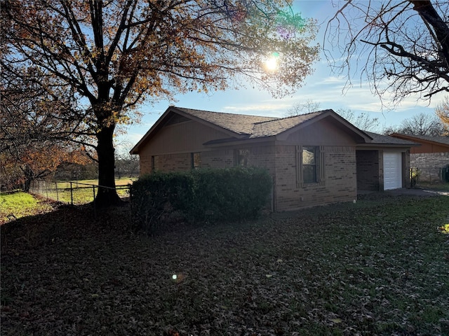 view of side of home featuring a lawn and a garage