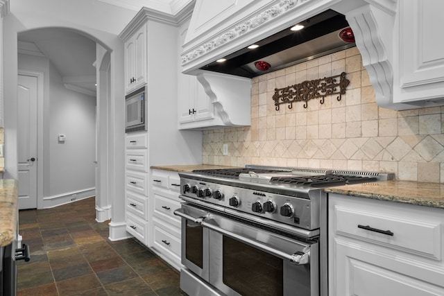 kitchen with appliances with stainless steel finishes, tasteful backsplash, and white cabinetry