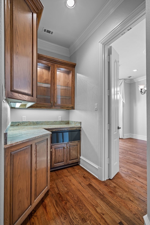 kitchen featuring ornamental molding, dark hardwood / wood-style floors, and light stone countertops