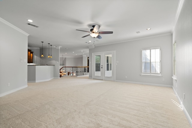 unfurnished living room with light colored carpet, french doors, ceiling fan, and ornamental molding