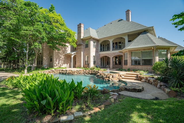 rear view of house featuring a yard and a balcony