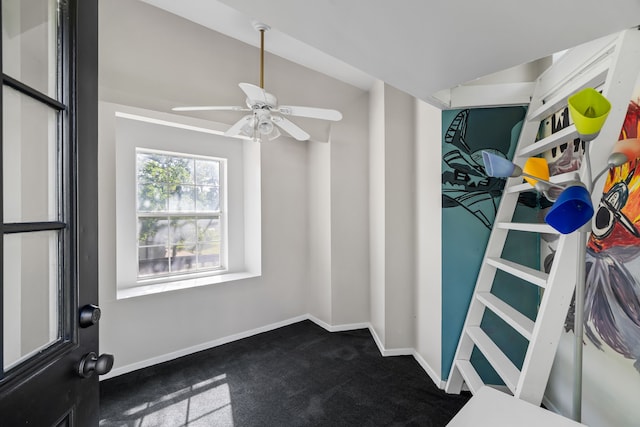 spacious closet featuring dark colored carpet and ceiling fan