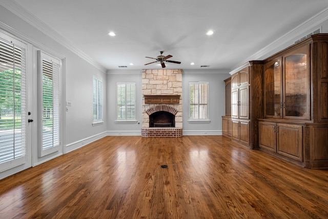 unfurnished living room with crown molding, dark hardwood / wood-style flooring, ceiling fan, and a fireplace