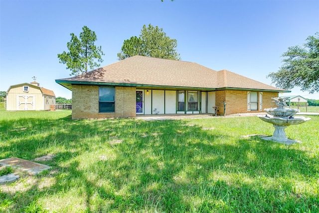 rear view of property featuring a yard and a storage shed