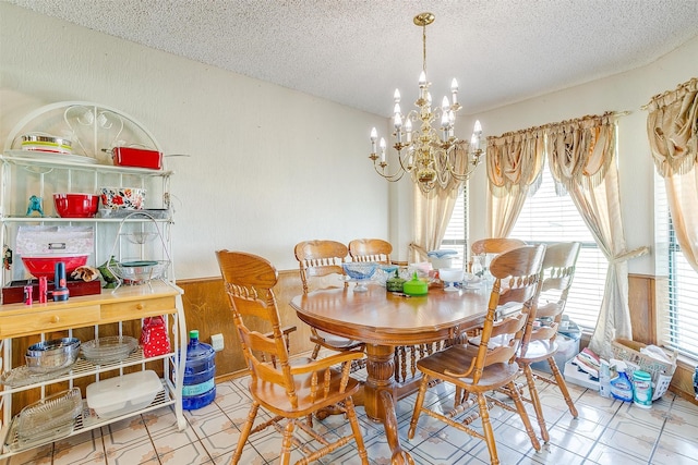 dining room with a textured ceiling, light tile flooring, and a chandelier