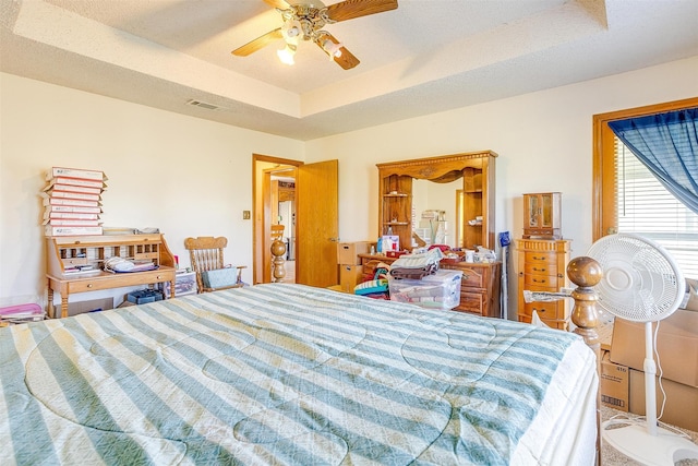 bedroom featuring ceiling fan and a tray ceiling